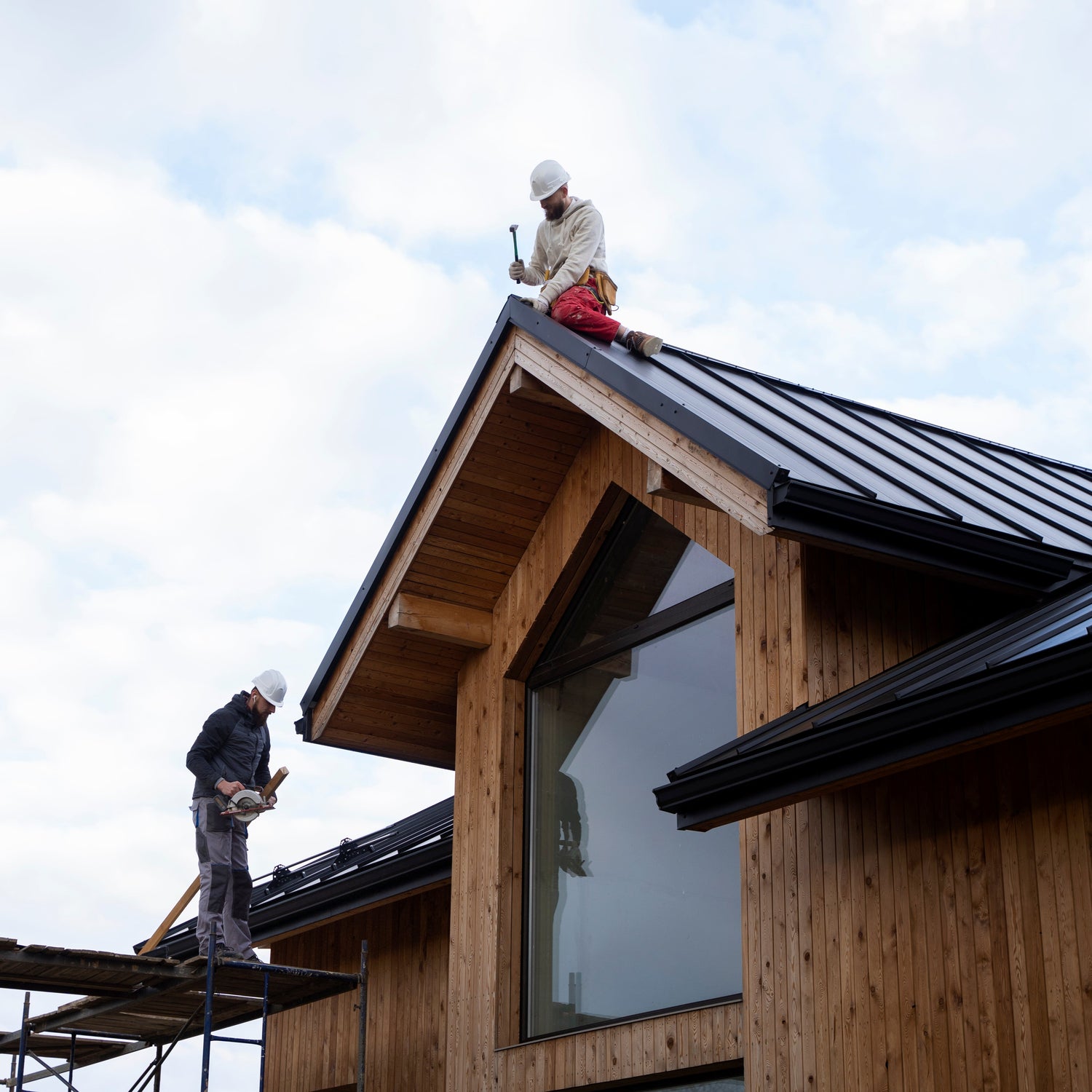 Two workers on a roof with a clear sky background