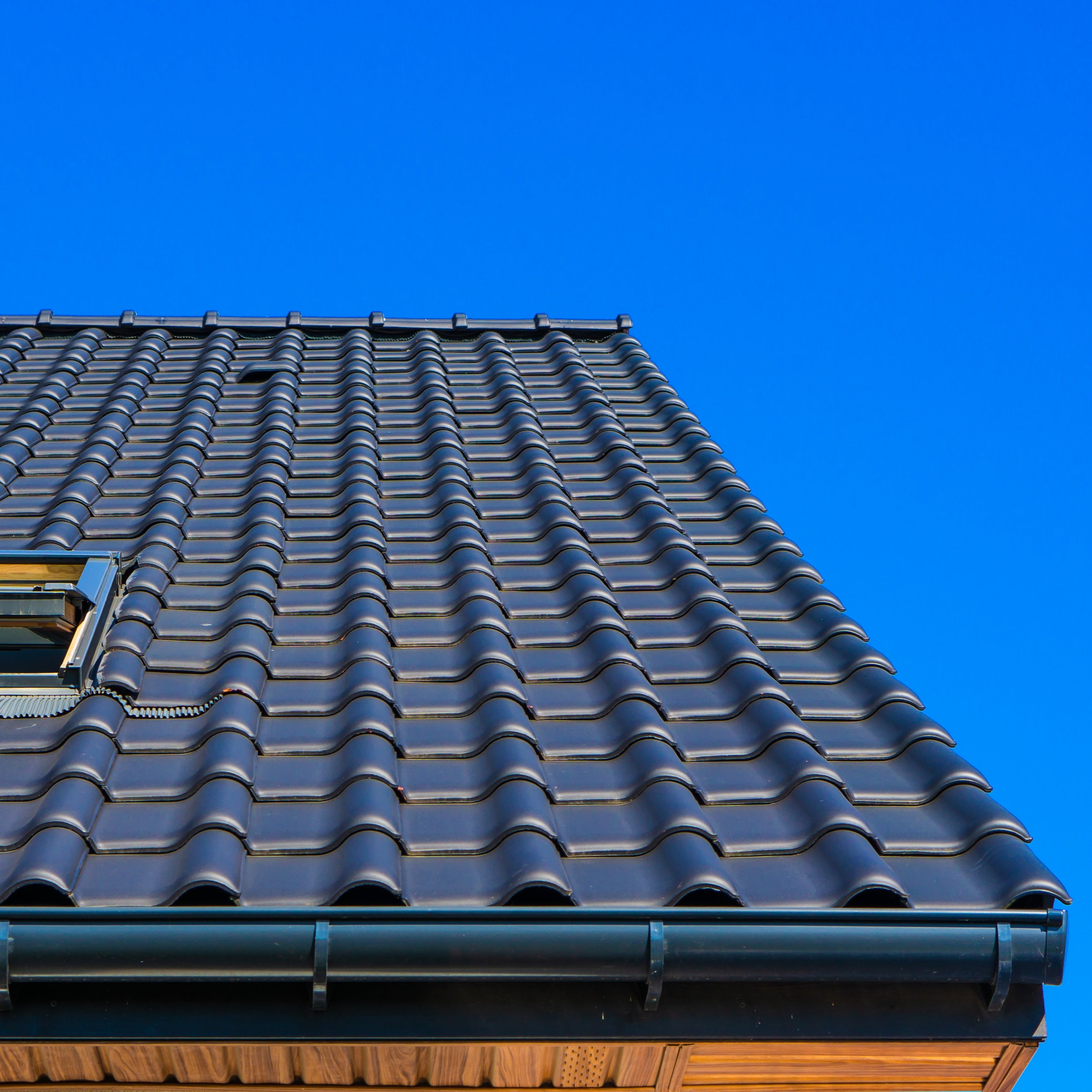 Roof with tiles against a clear blue sky